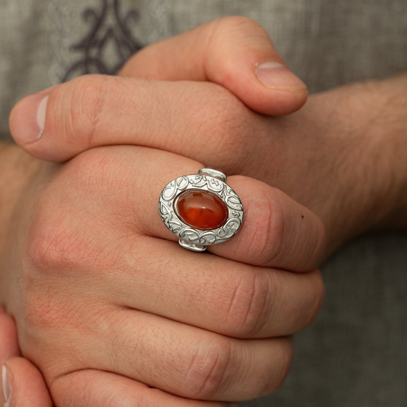 Photo of the model's clasped hands wearing the Roots Don't Fade Stone Ring | Men on their right index finger.
