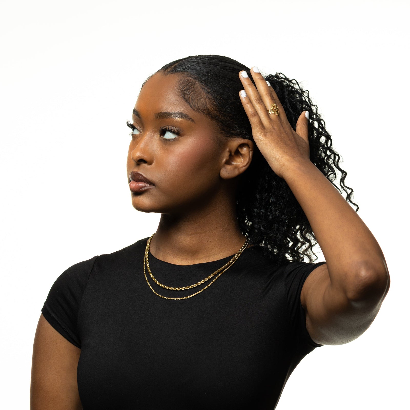 Photo of the model touching their head with their left hand looking away from the camera. The model is wearing two gold Rope Chain Necklace in different sizes.