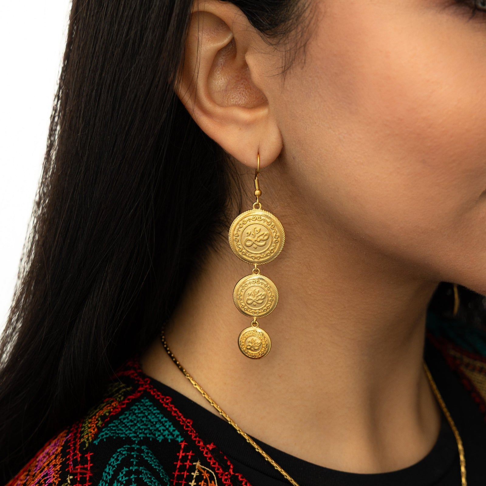 Gold Sabr | Patience Coin Earring as worn by the model on their right ear.