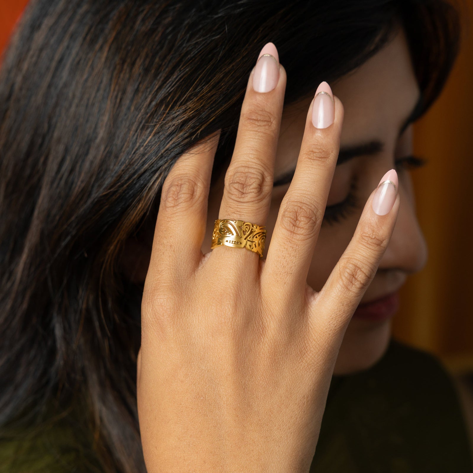 Model wearing a gold Ease Ring on her finger.