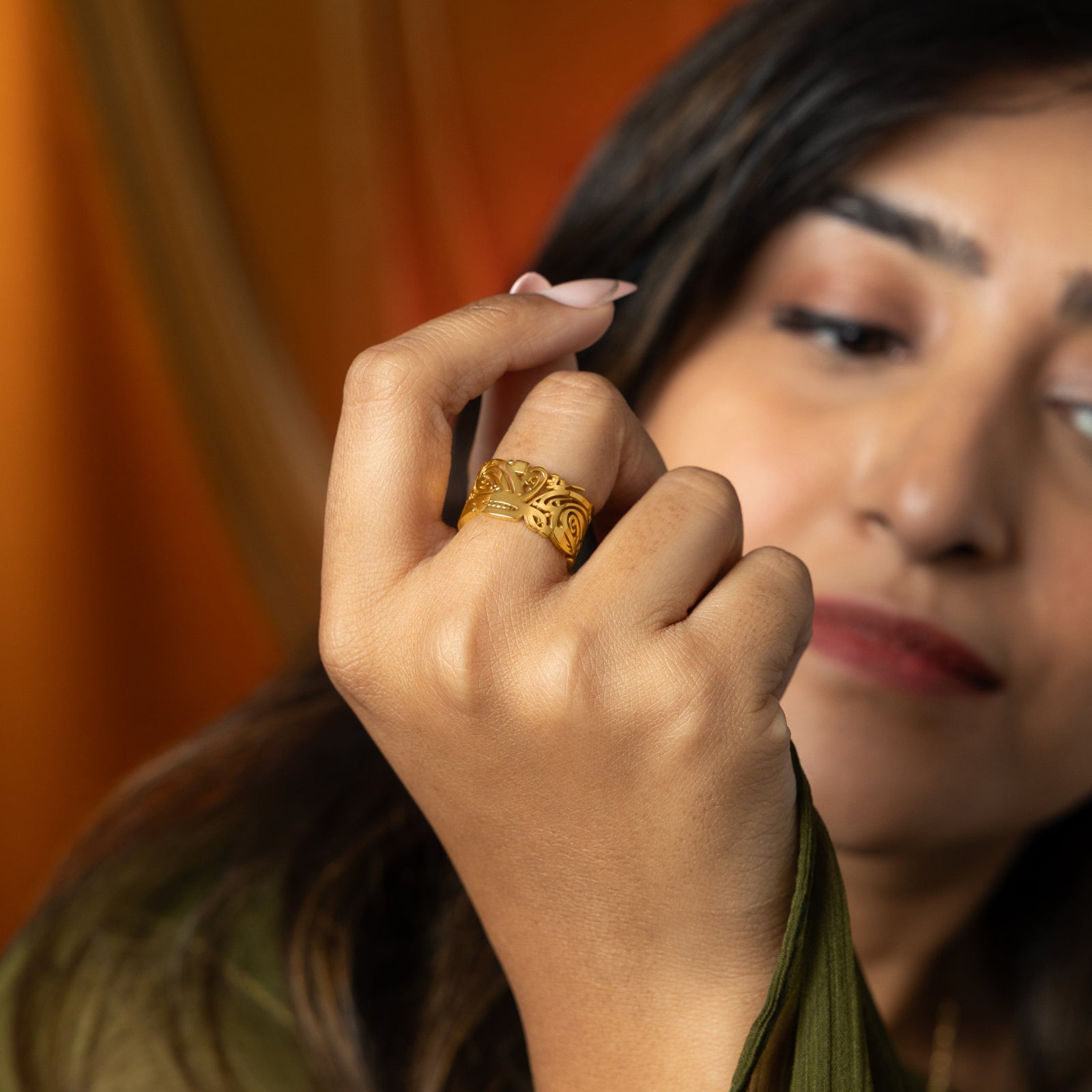 Model wearing a gold Ease Ring on her finger.