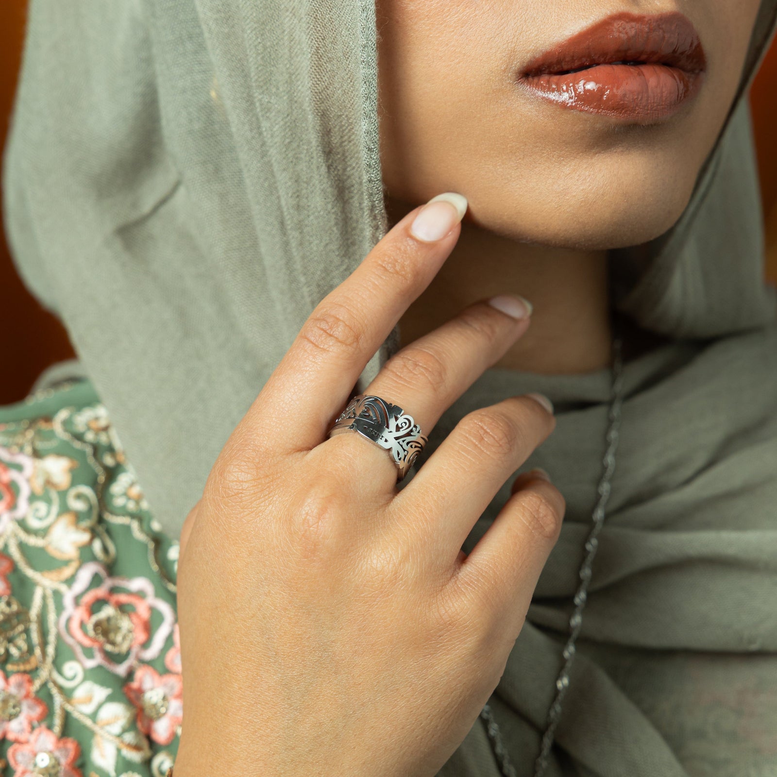A person wearing a silver ease ring.