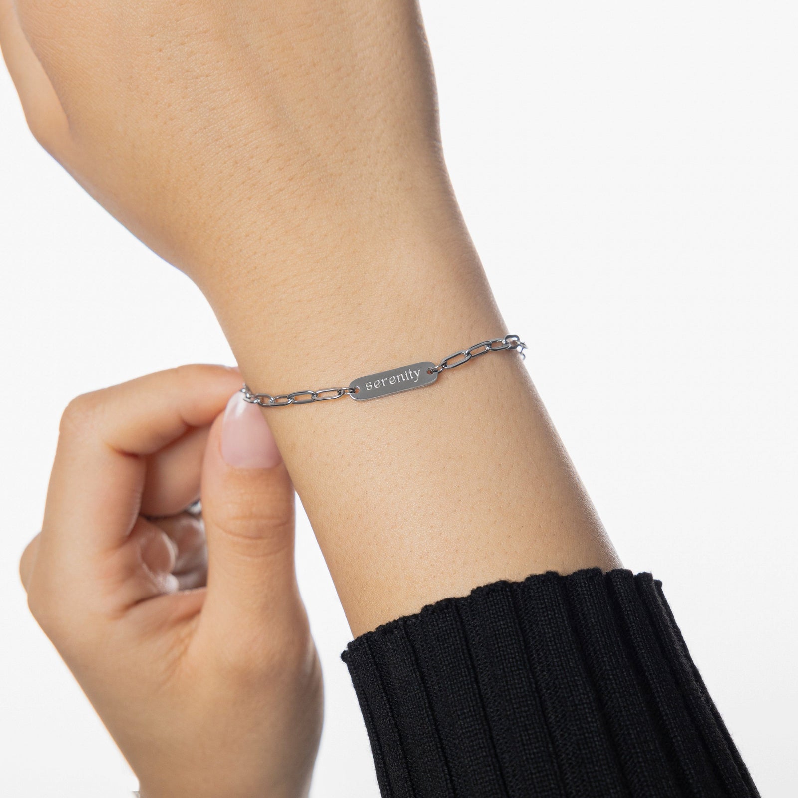Woman wearing silver Sakinah Serenity bracelet, showing the english text engraving.