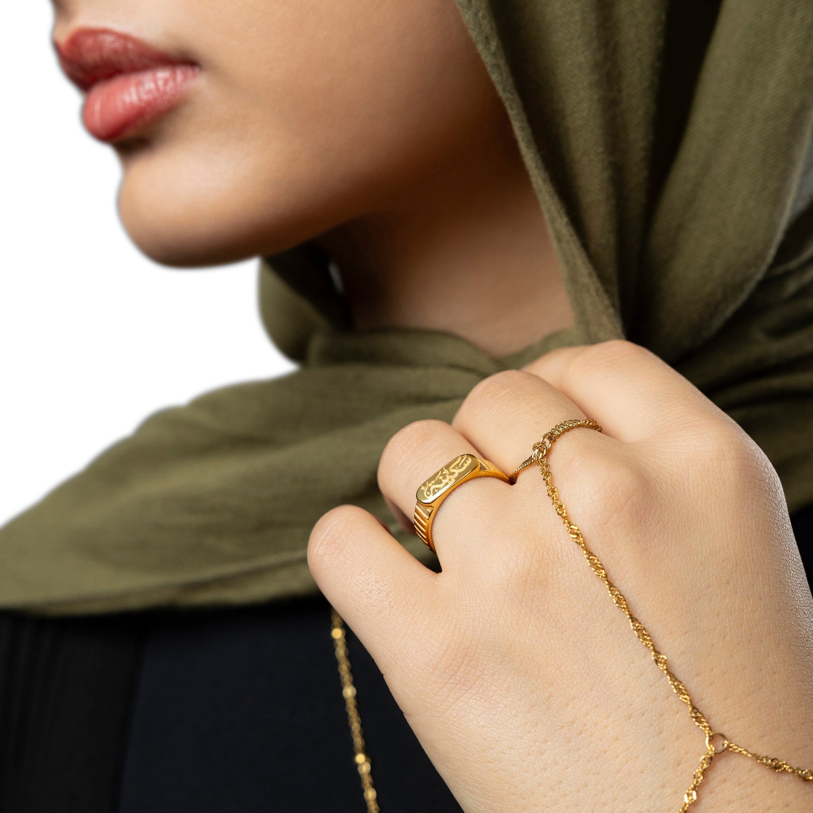 Woman in green hijab wearing the Sakinah  serenity gold ring and twisted hand chain.