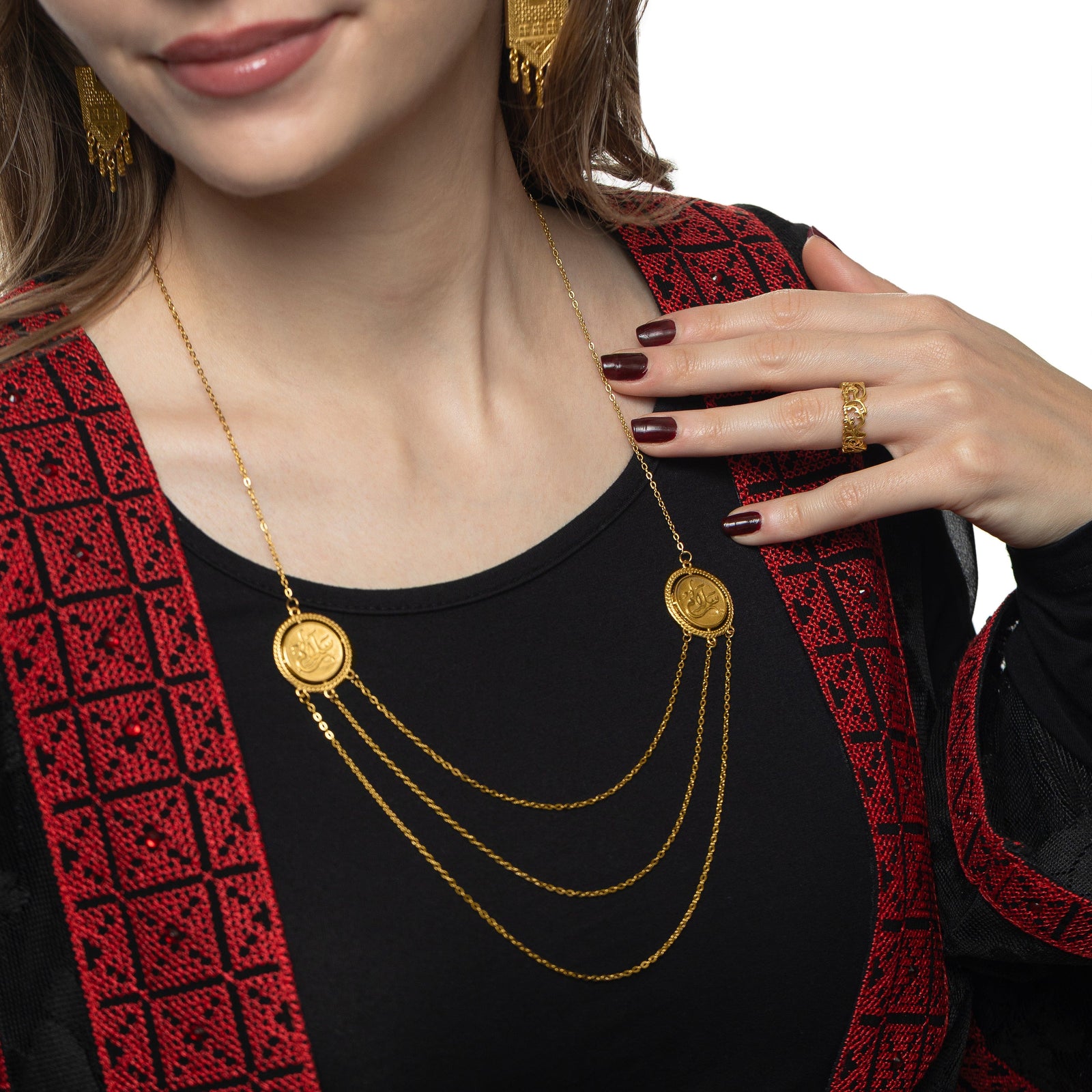 Close up photo of the gold Salam | Peace Layered Token Necklace worn by the model. The model is touching the thin chain.