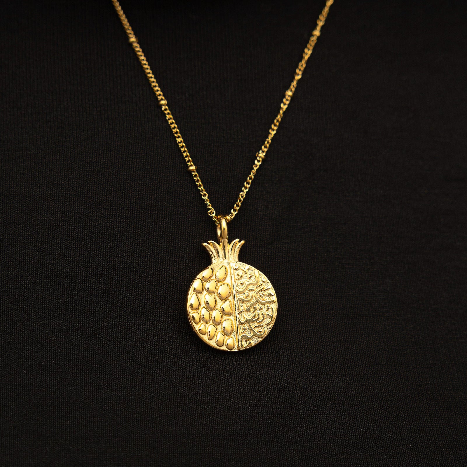Gold Seeds of Gratitude Necklace on a black background.