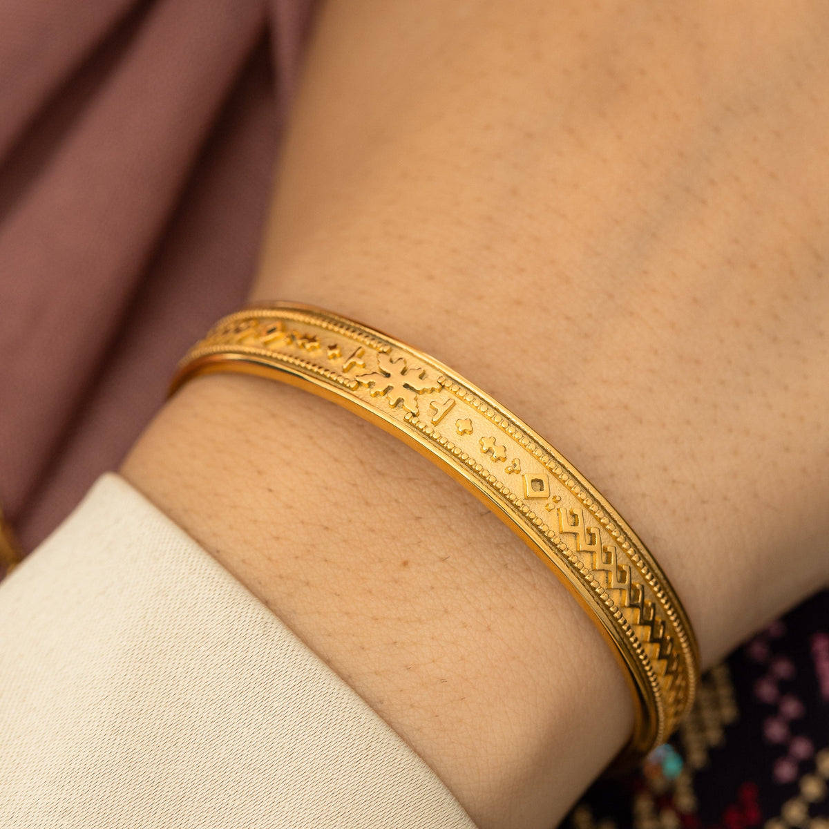 Close up picture of the gold cuff as worn by a model.