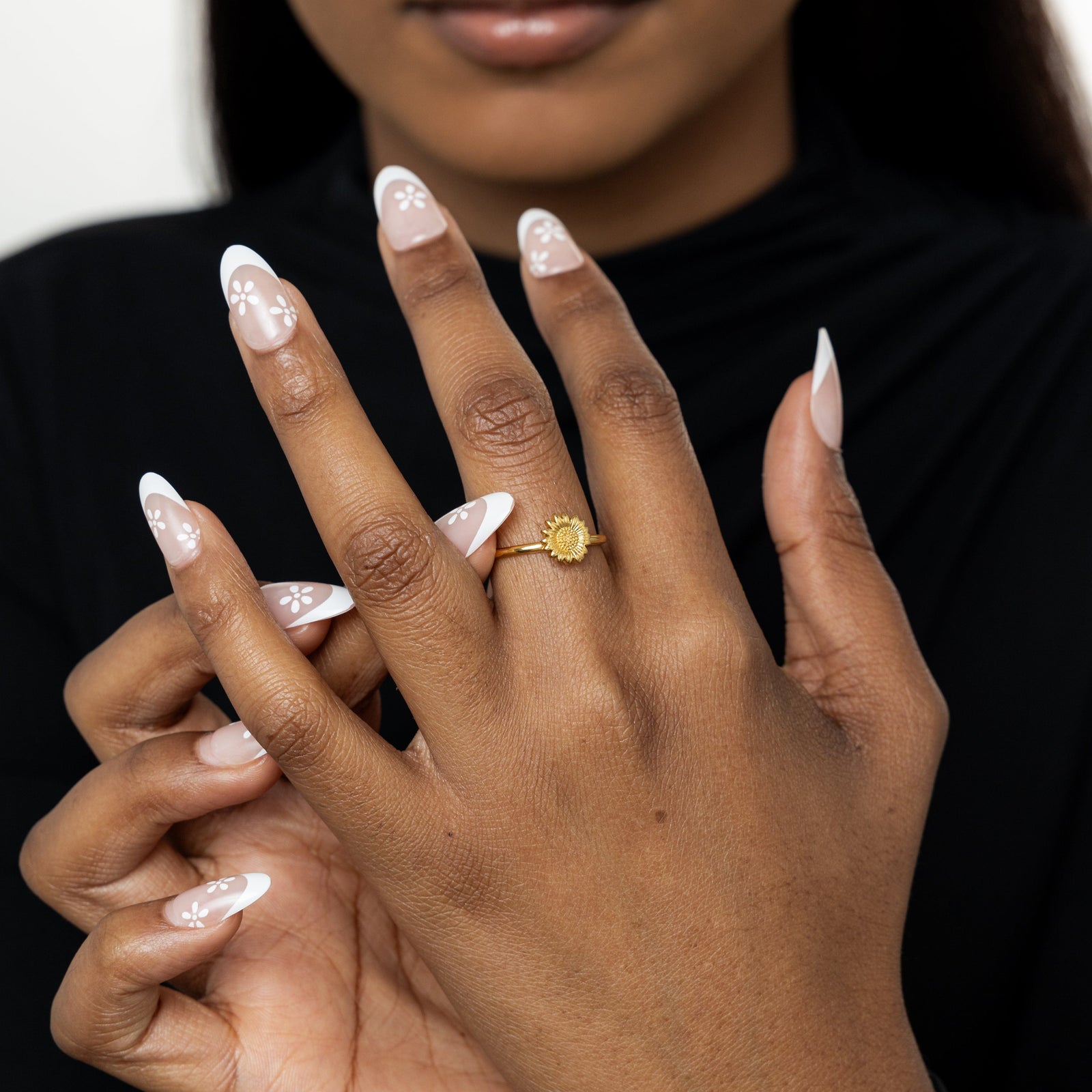 Close-up of hands , one hand showing the gold sunflower ring centered on the finger.