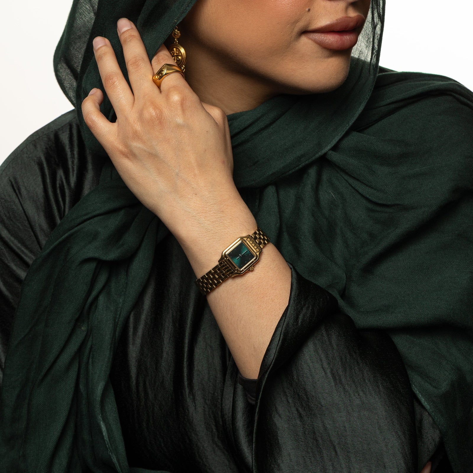 Model holds their hijab. Model is wearing the Aurora watch on her left wrist.
