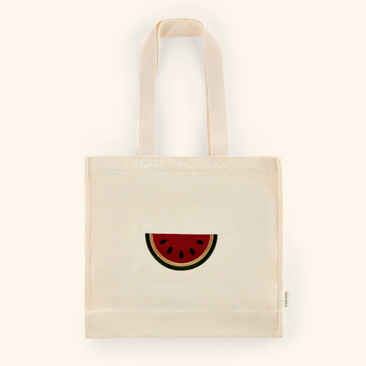 Textured cotton canvas tote with embroidered watermelon art in red, black, white, and green colors on the middle.
