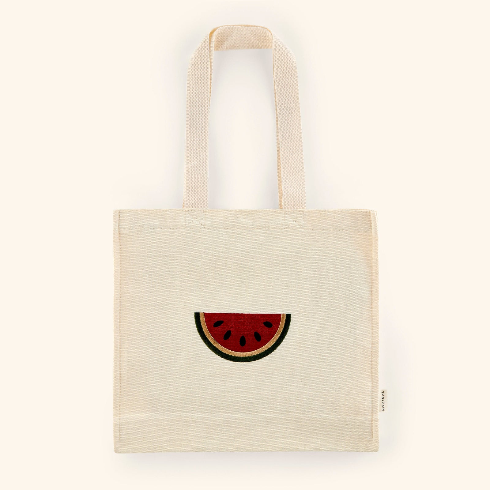 Textured cotton canvas tote with embroidered watermelon art in red, black, white, and green colors on the middle.
