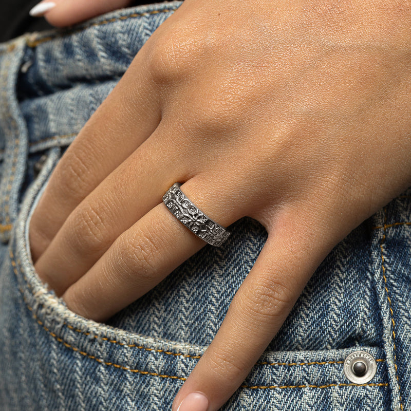 Woman wearing a silver Tatreez Ring with raised tatreez patterns on her finger in a close-up hand shot.