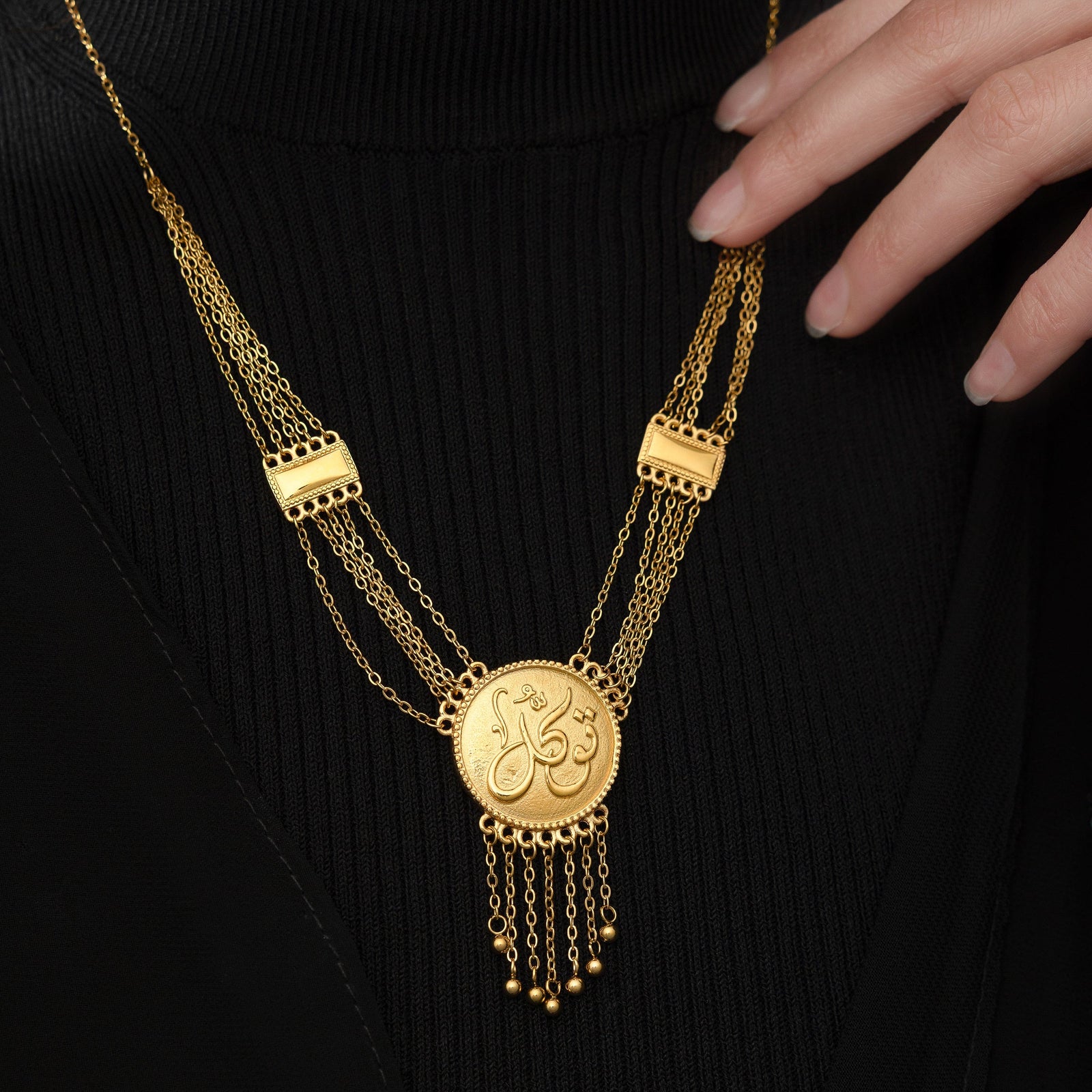 Model touching the chain of the gold Tawakkul | Trust Draping Necklace.