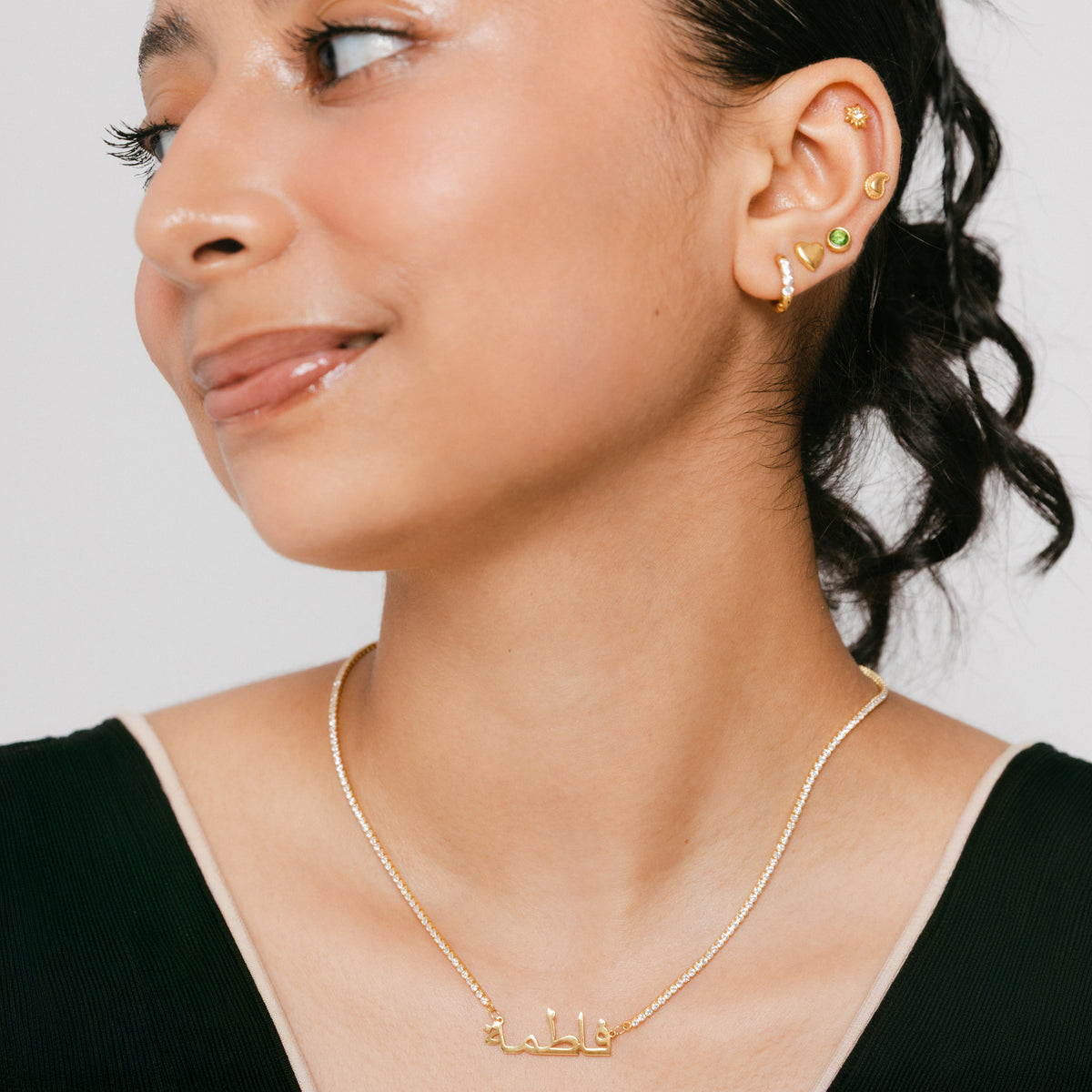 Model wearing 18k gold-plated Tennis Name Necklace featuring a clear pavé crystal chain with a central custom Arabic calligraphy nameplate.