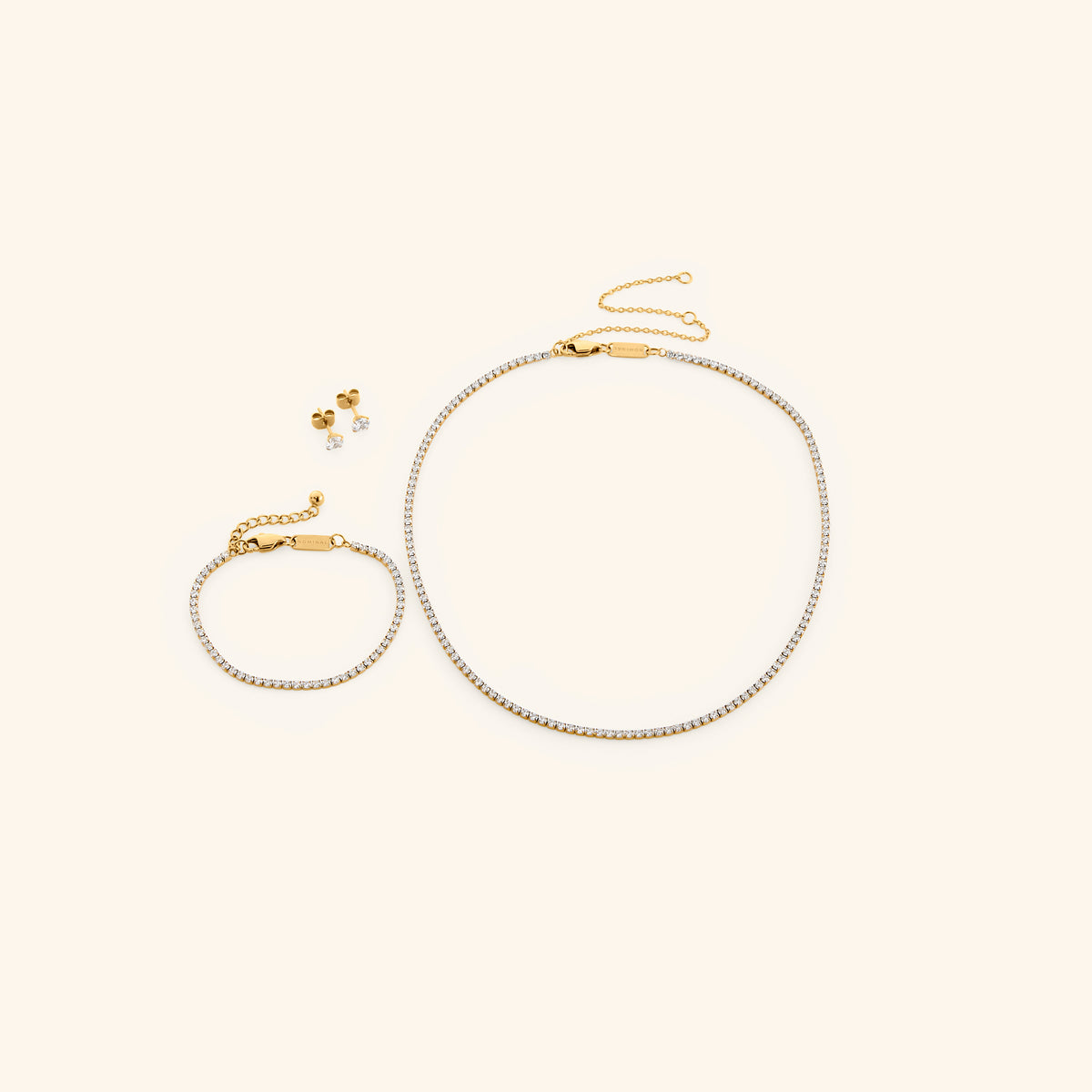 18k gold-plated Tennis Set featuring the Tennis Necklace, Tennis Bracelet, and Tennis Earrings.