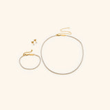 18k gold-plated Tennis Set featuring the Tennis Necklace, Tennis Bracelet, and Tennis Earrings.