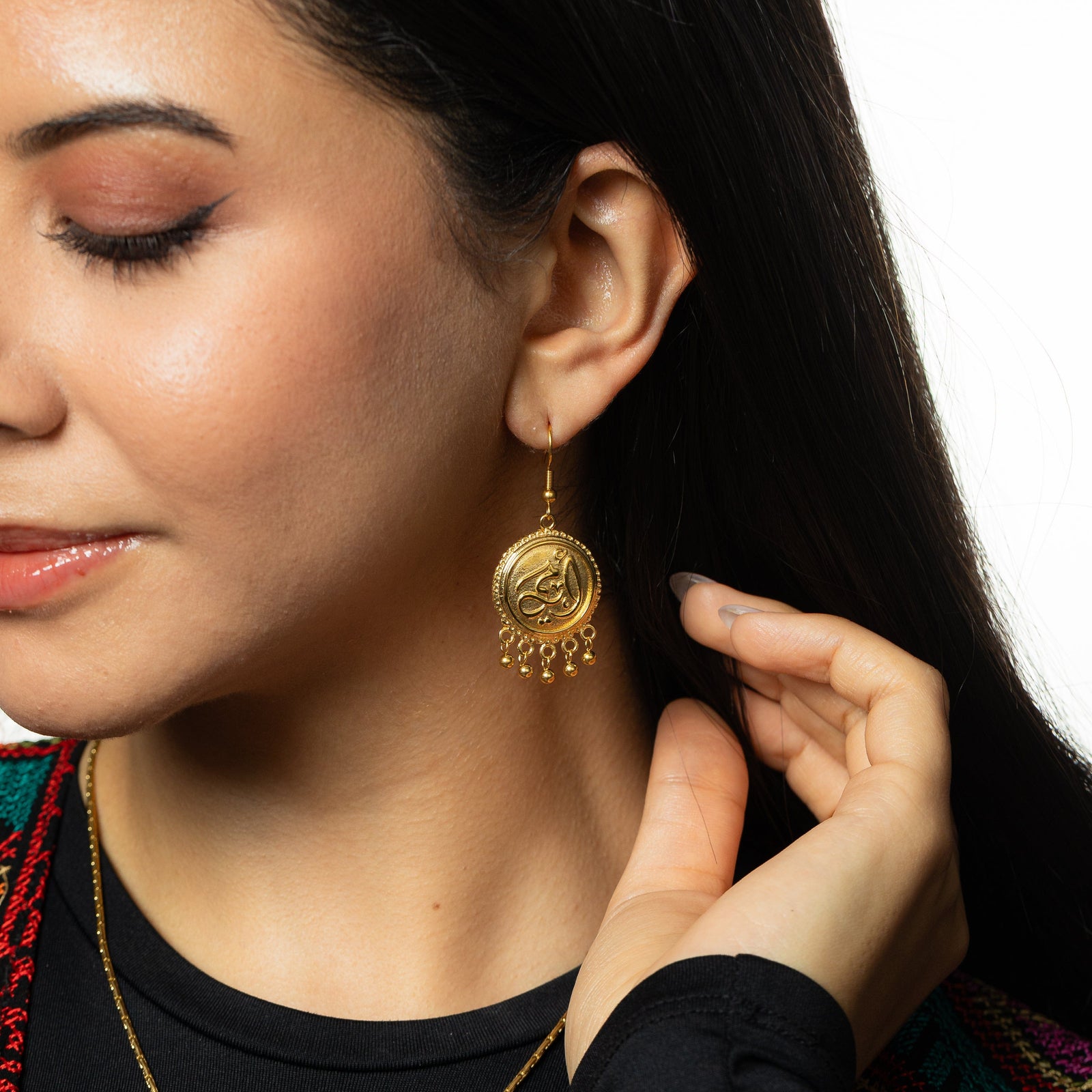 Photo of the the Ummi | Mother Coin Earring as worn by the model. Model is touching their hair.