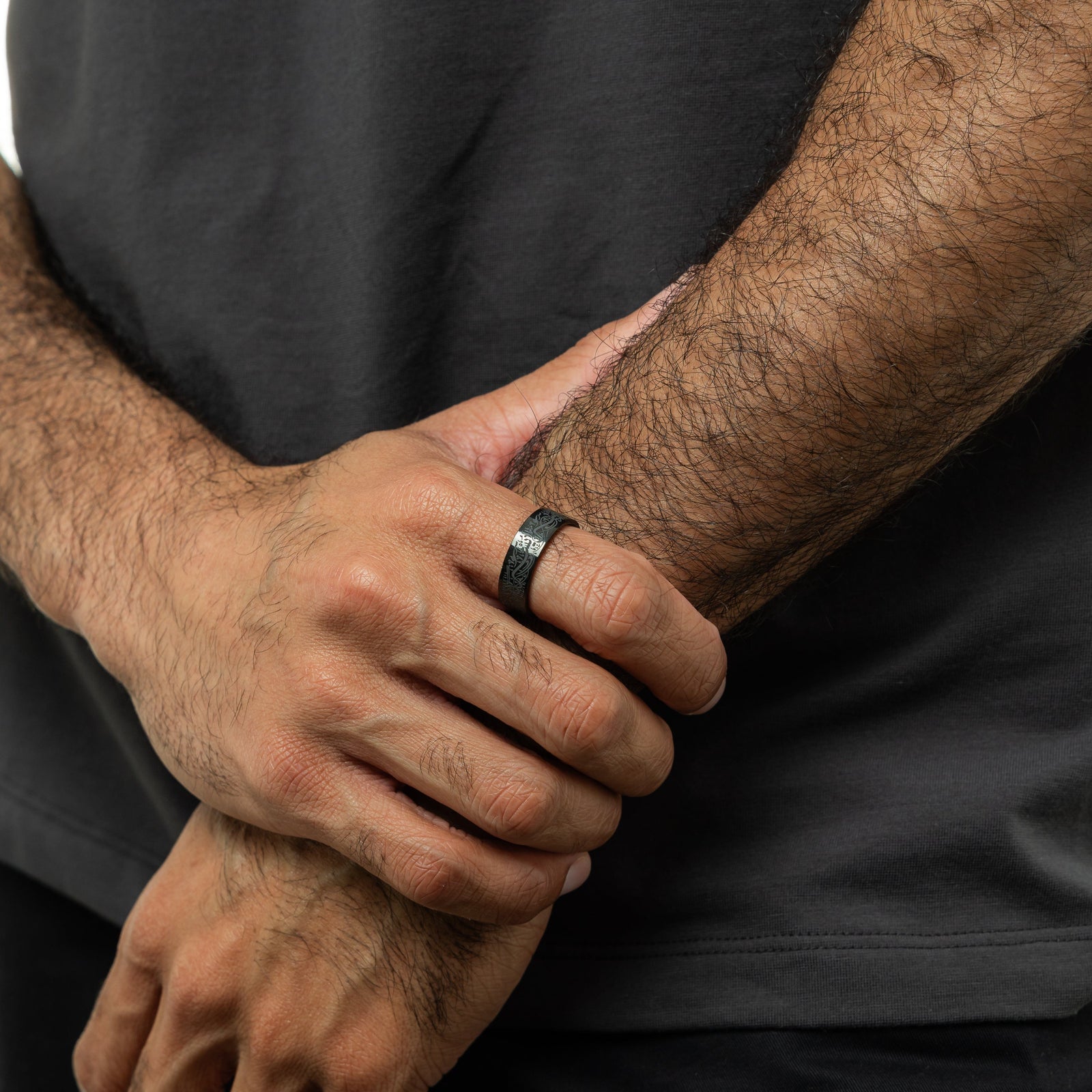 Photo of the model's hands. The model is wearing the black "With Hardship Comes Ease" Ring V2 | Men on their right index finger.