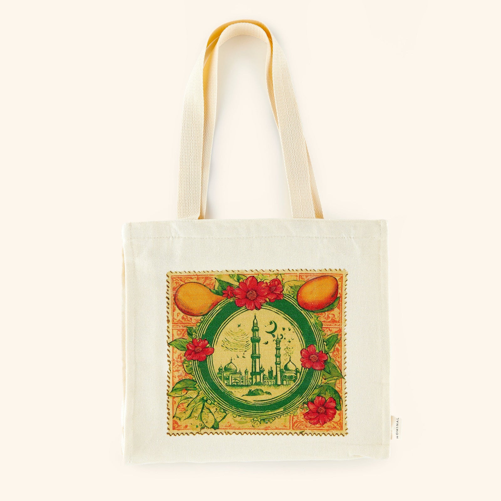 Photo of a beige tote bag that is  designed with a colorful print reminiscent of a vintage stamp, adorned with architecture from Pakistan, fruits and flowers, and other elements to bring a beautiful collage together. 
