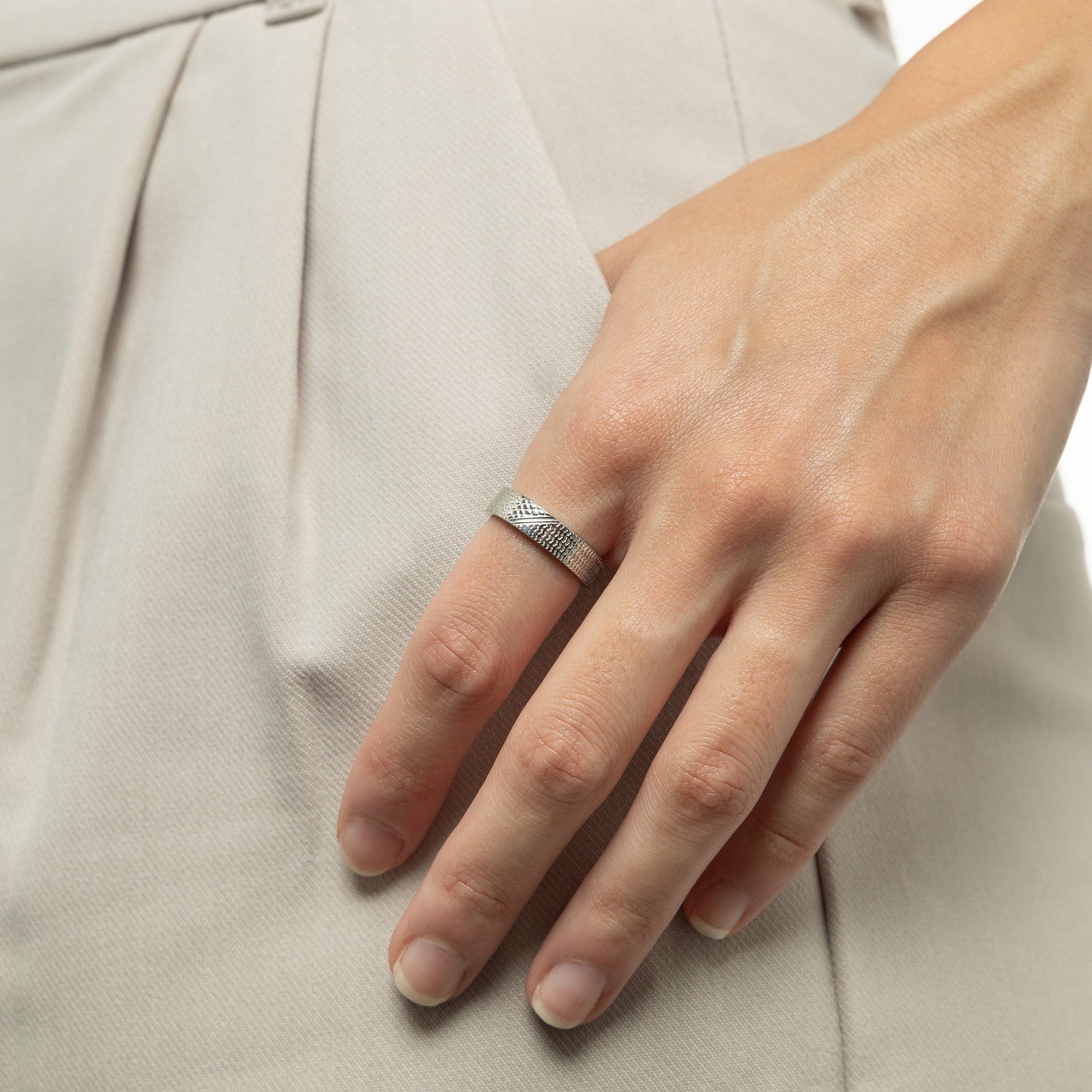 A female model wearing the 18K gold plated Keffiyeh Ring on her index finger. 