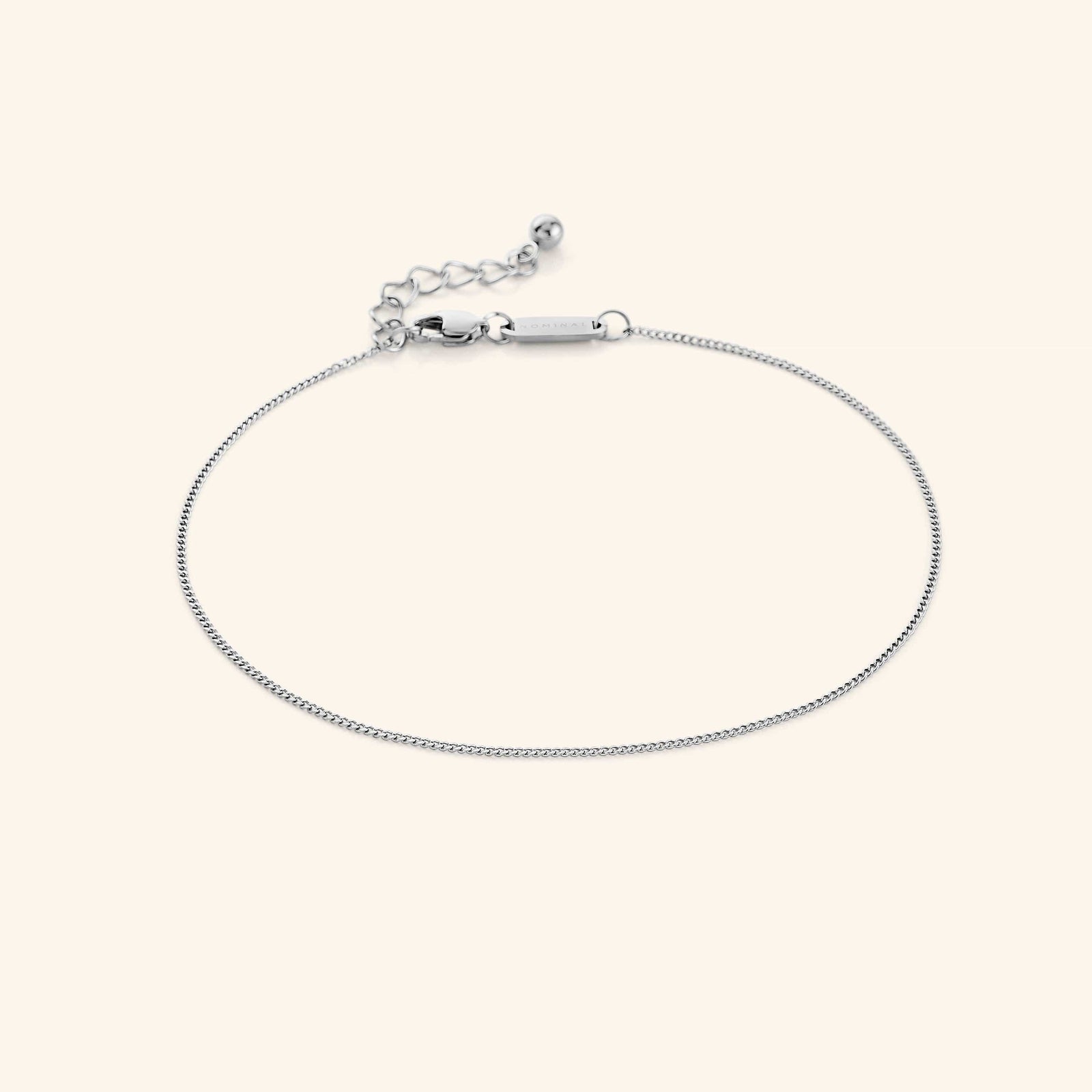 Photo of the silver Micro Curb Anklet against a light background. This anklet features a 1MM flat oval chain pattern