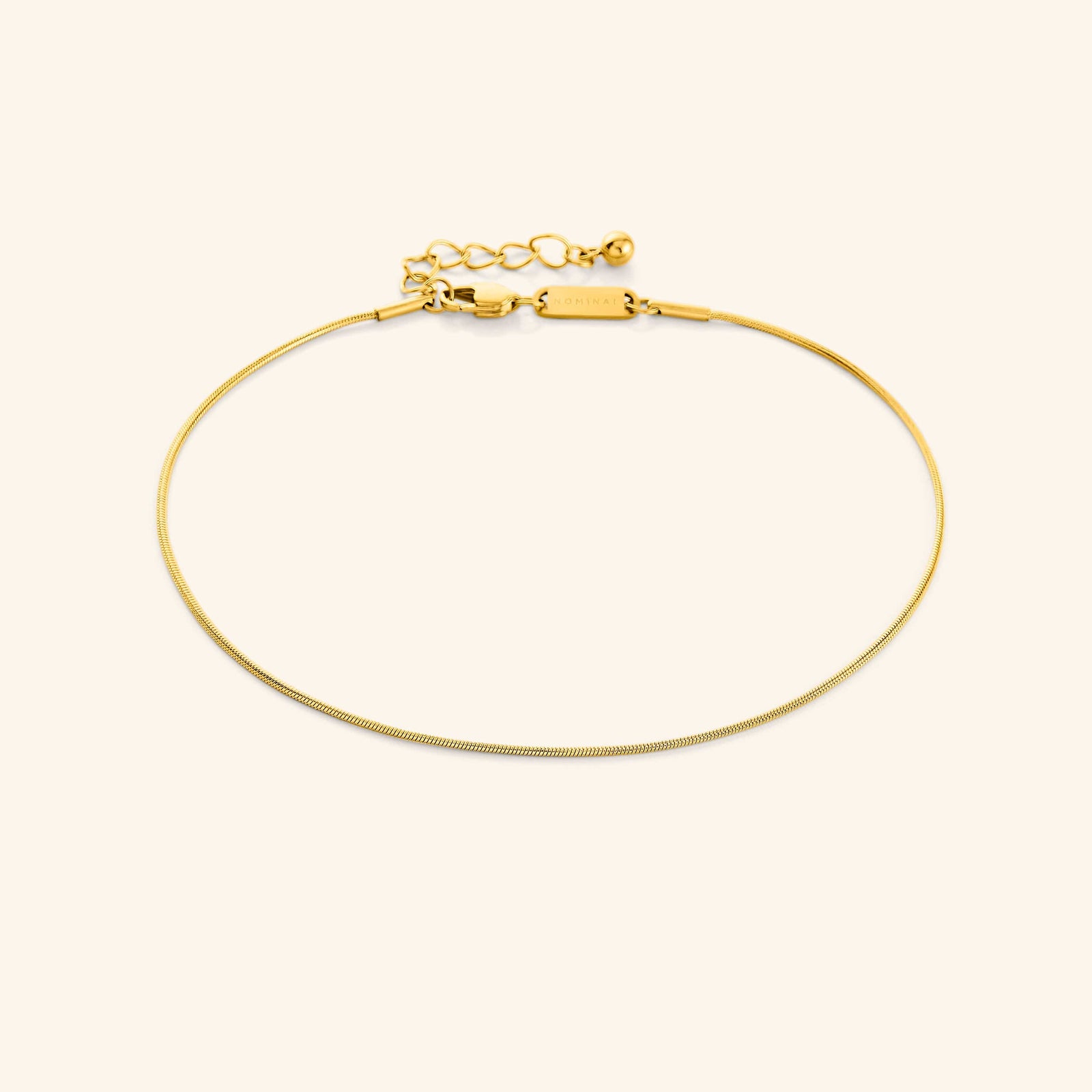 Photo of the 18k gold plated  Micro Harmony Anklet against a light background. This anklet features a 1MM seamless snake-like chain pattern