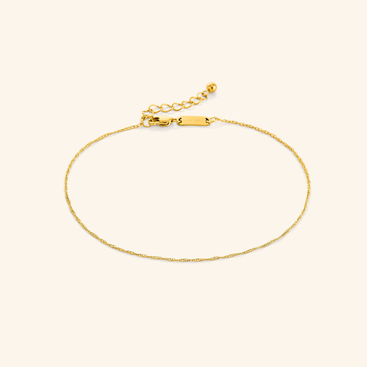 Photo of the gold Micro Twisted Anklet against a light background. This anklet features a 1MM twirling chain pattern.
