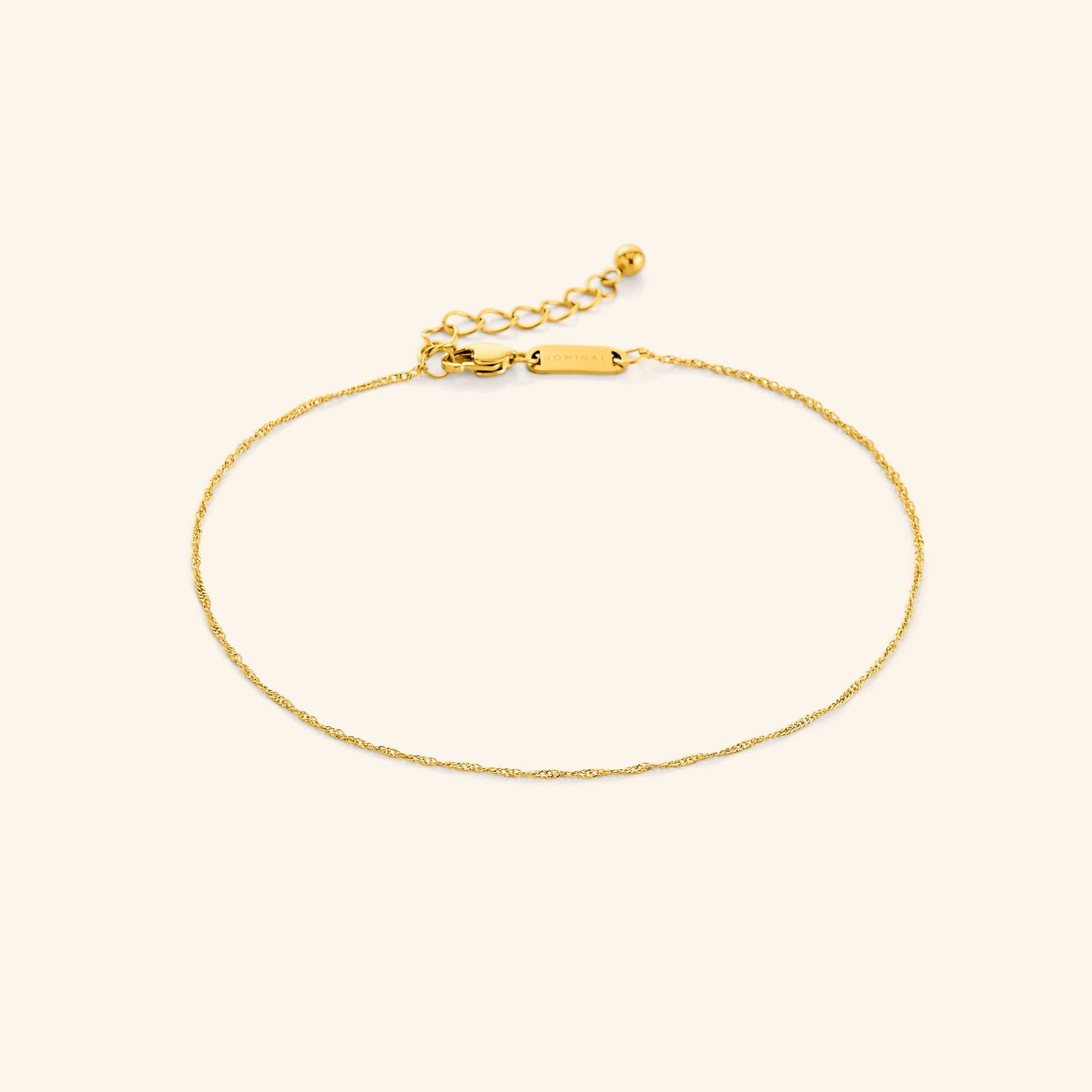 Photo of the gold Micro Twisted Anklet against a light background. This anklet features a 1MM twirling chain pattern.