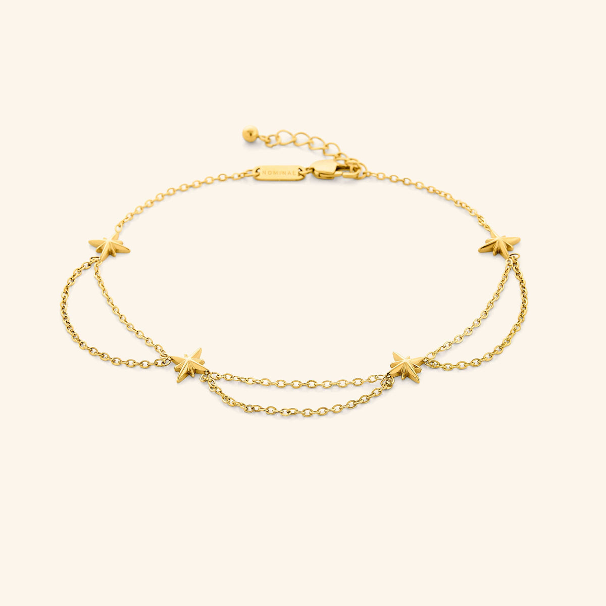 An 18k gold plated anklet that features north stars all along the chain, drooping chains connecting each one design.