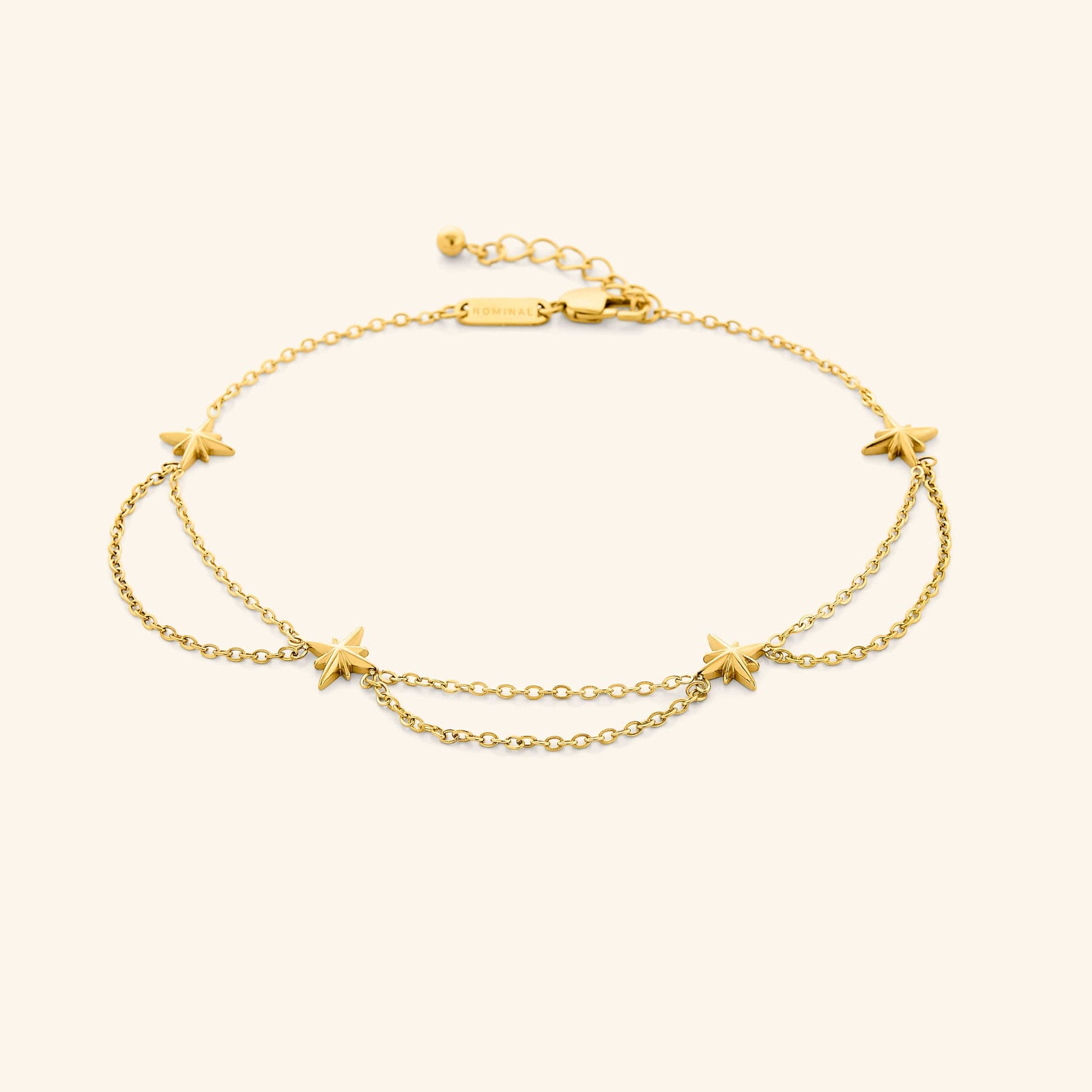 An 18k gold plated anklet that features north stars all along the chain, drooping chains connecting each one design.
