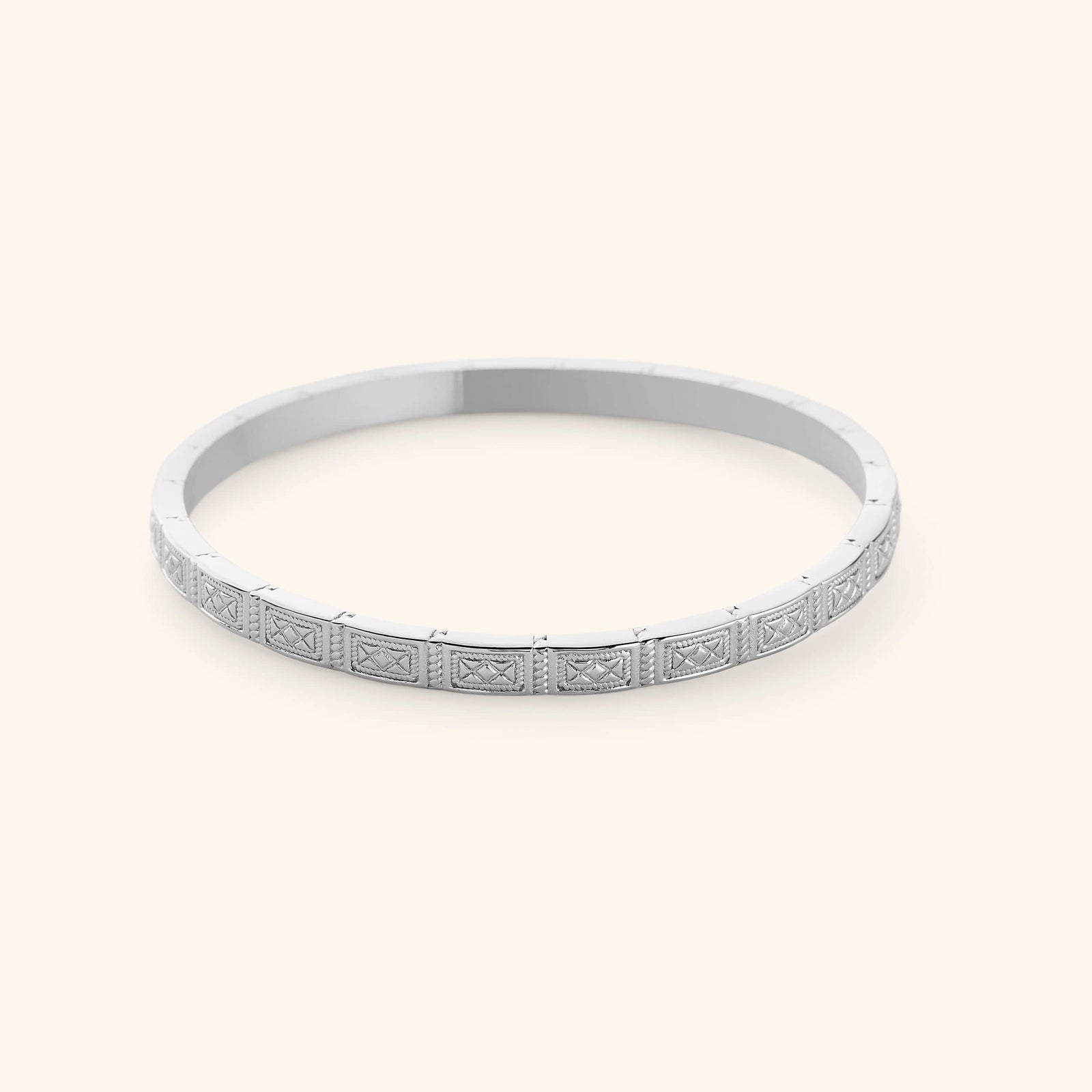 A slim silver bangle etched with geometric patterns pulled from Damascus tilework.