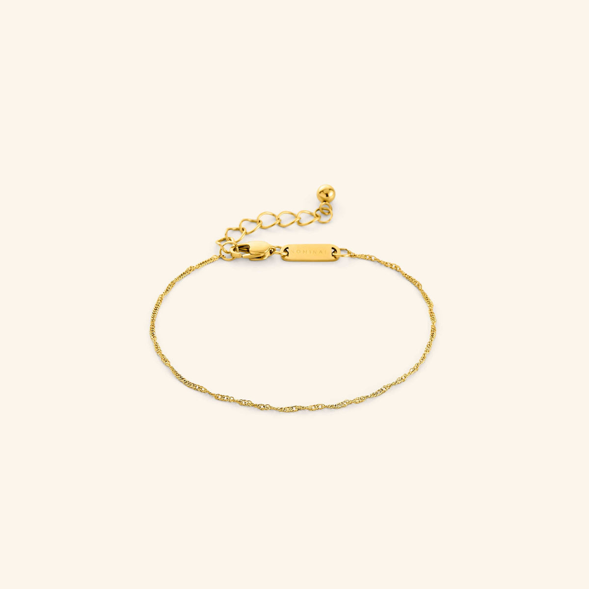 Flat lay of an 18k gold plated Micro Twisted Bracelet. The Invisible Twisted Bracelet features a 1MM twirling chain pattern.