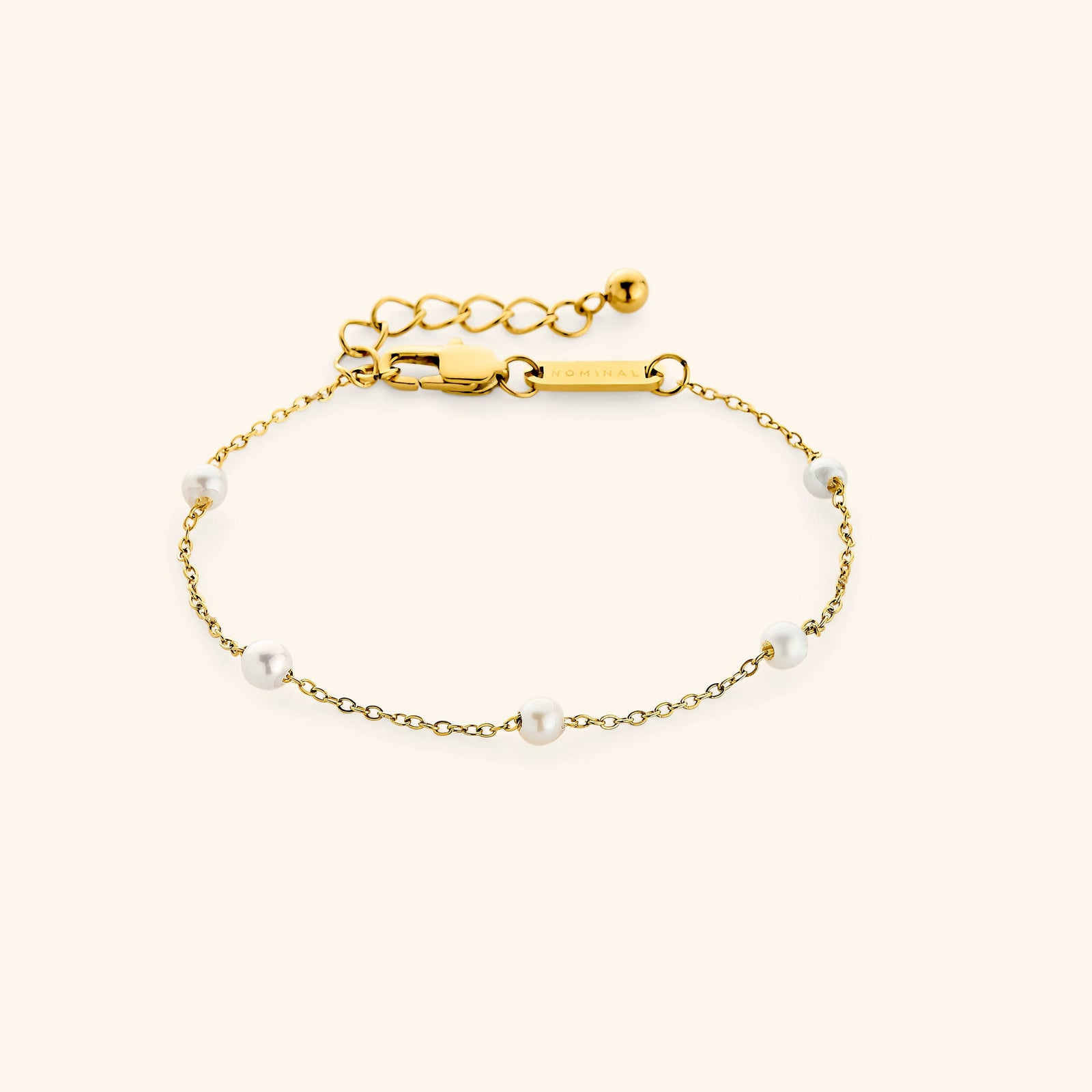 Flat lay of an 18k gold plated bracelet. The Pearl Strand Bracelet features an array of pearls along a cable chain.
