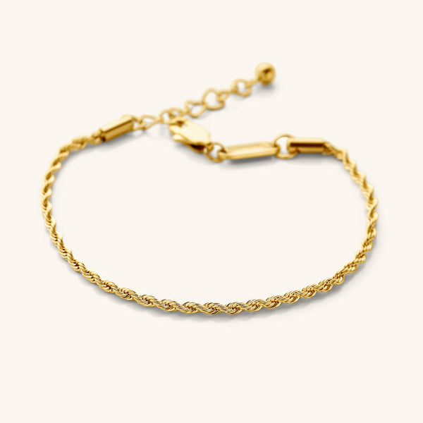 Flat lay of the 18k gold plated essential rope bracelet that features a woven chain pattern.