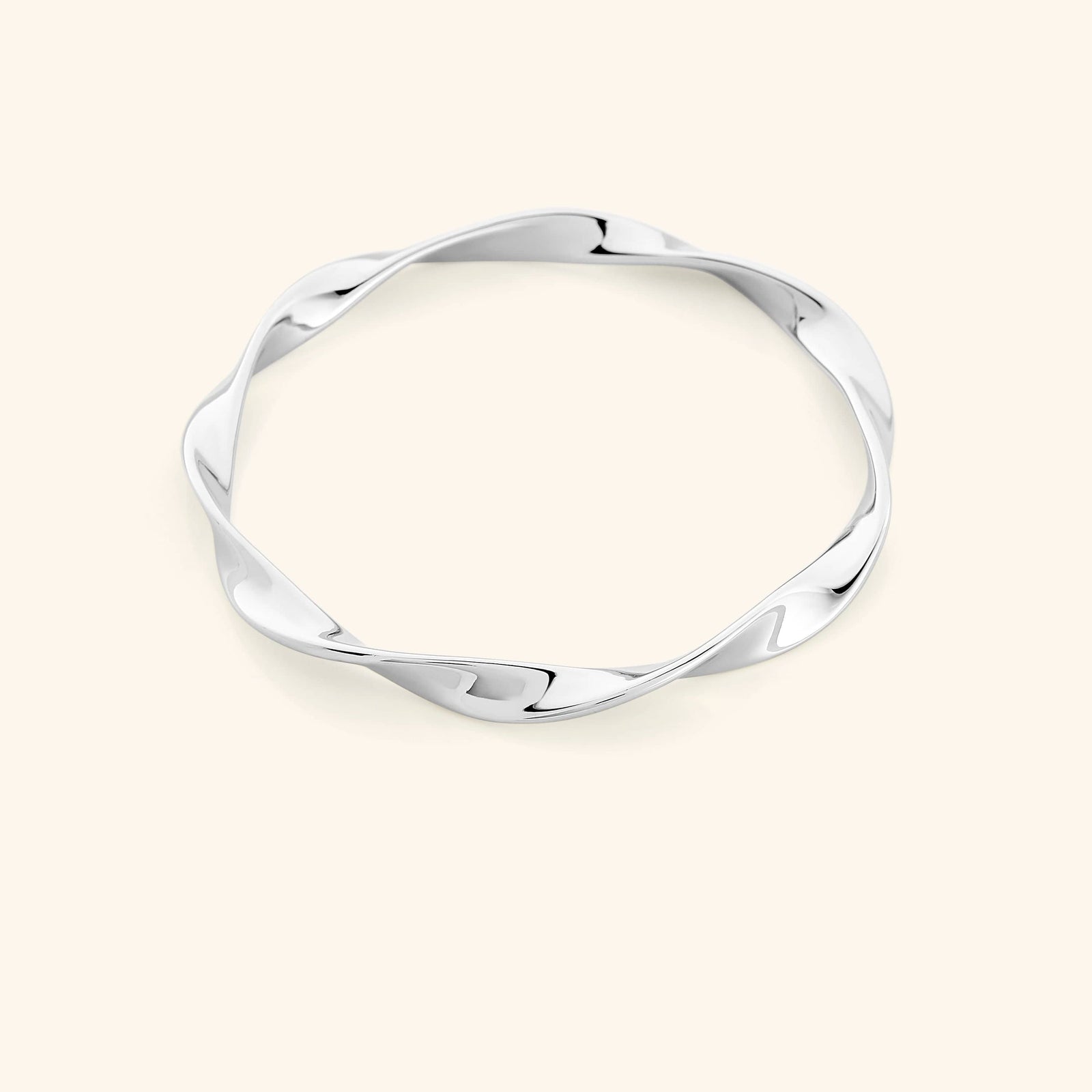 A silver bangle that features a design that is inspired by the ripple effect that even a small drop of water can have in an ocean.