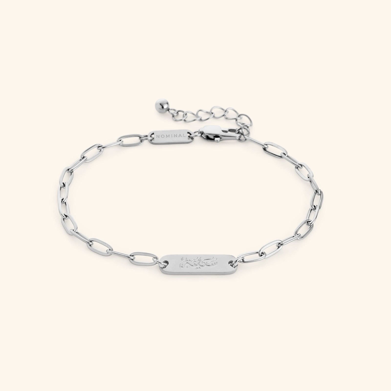 Silver Sakinah Serenity link bracelet showing the Arabic engraving on center tag, photographed against a light background.