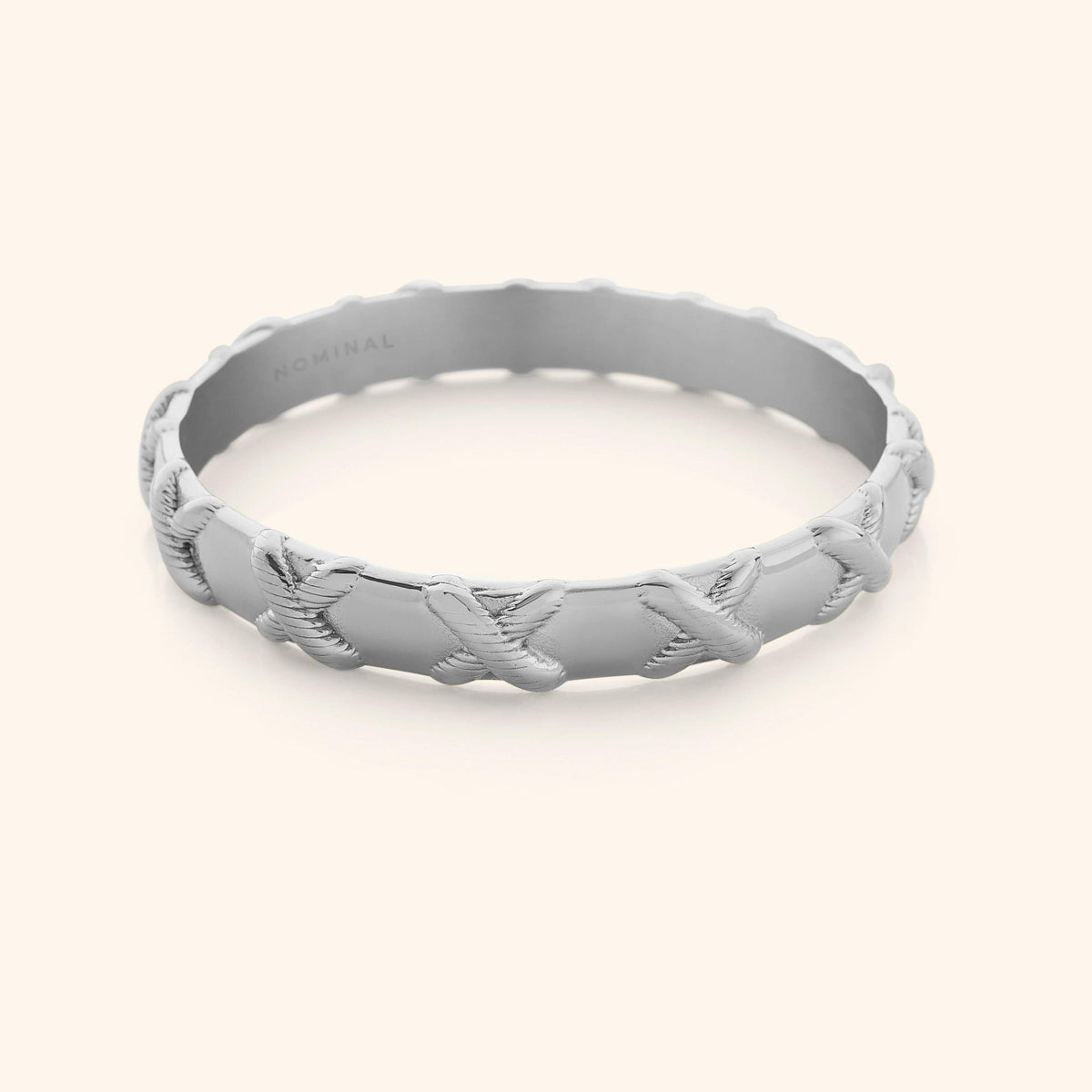 Photo of silver bangle that is designed with embossed X around the bangle.