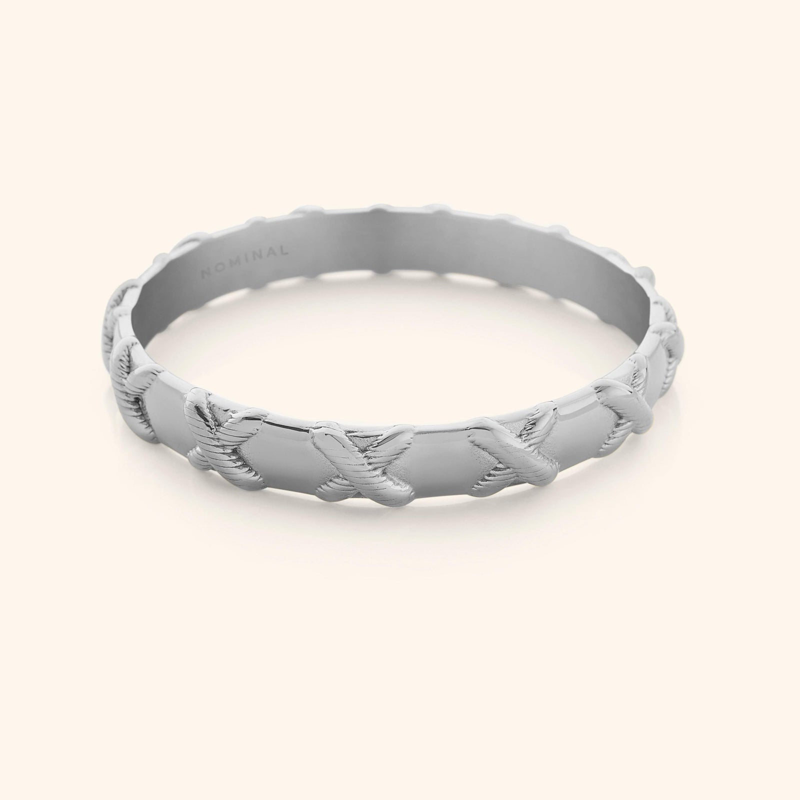 Photo of silver bangle that is designed with embossed X around the bangle.