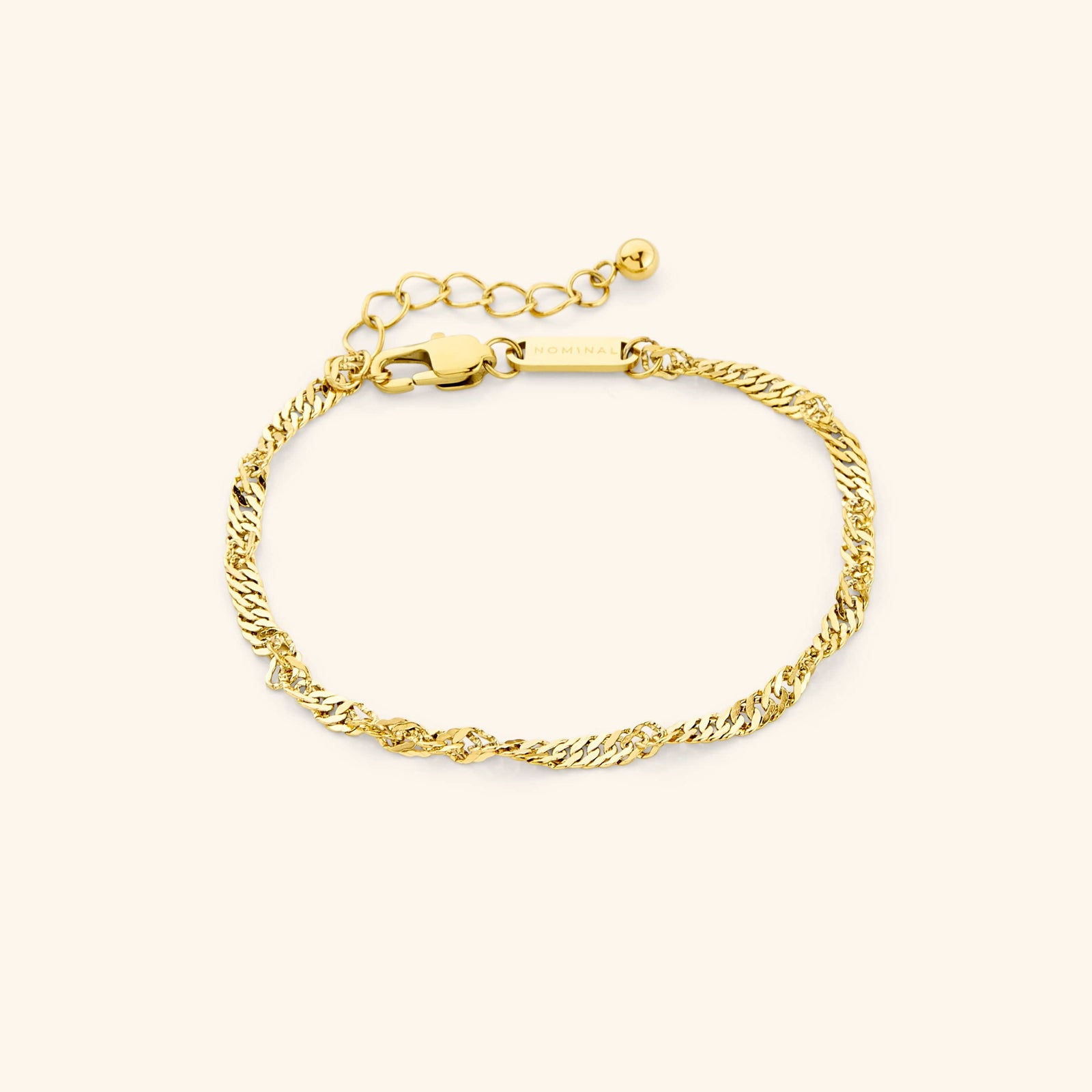 Medium-thickness gold twisted chain bracelet in a circular layout on a cream background. Visible text “NOMINAL” engraved on the tag near the clasp.