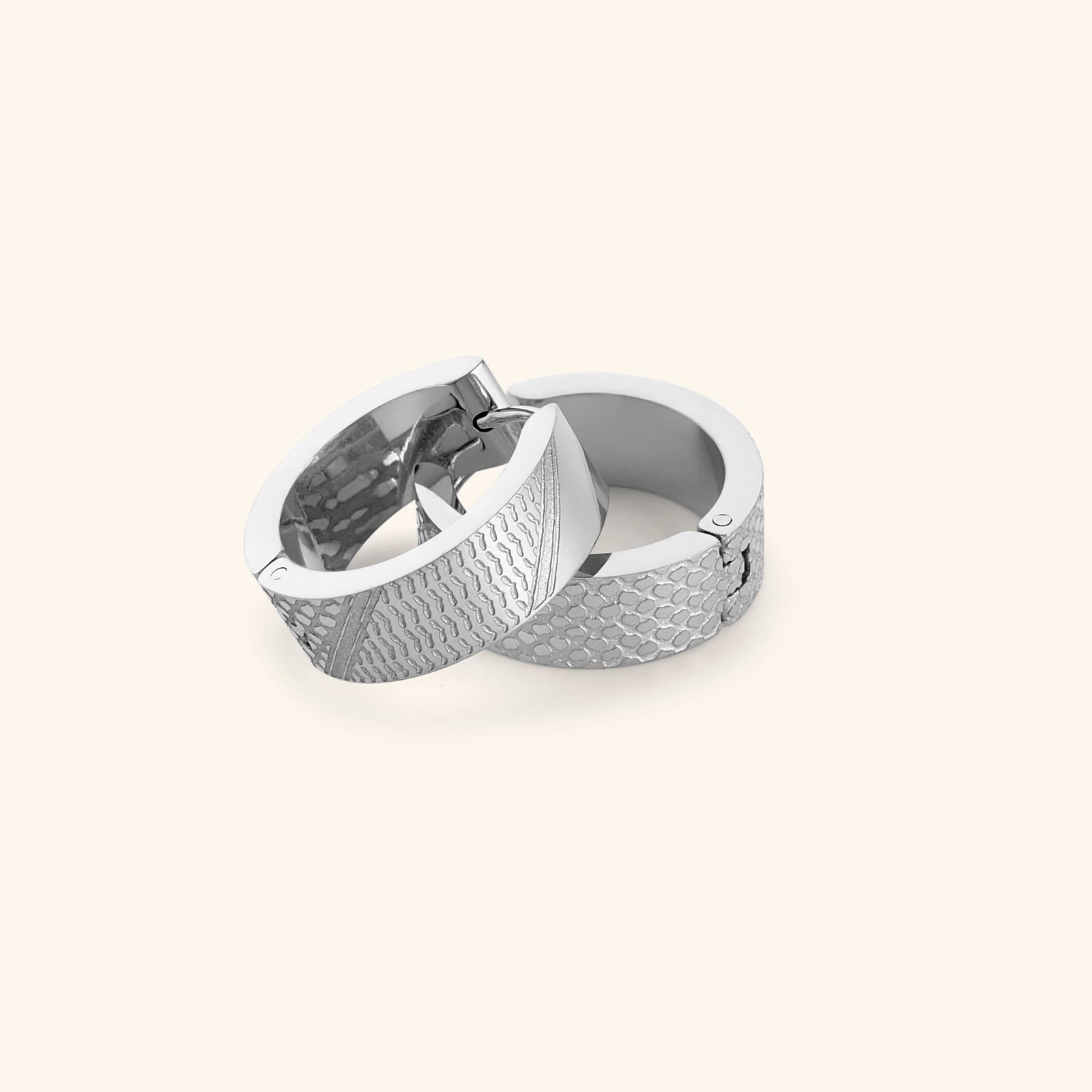 Pair of silver keffiyeh chunky hoops on a light background