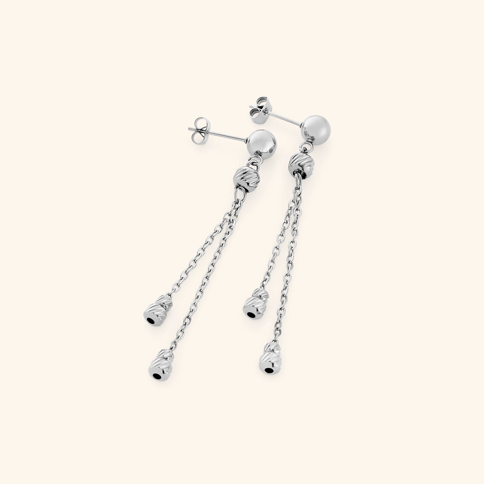 Pair of silver raining earrings featuring a polished stud with two slim chains, each ending in ribbed silver bead charms.