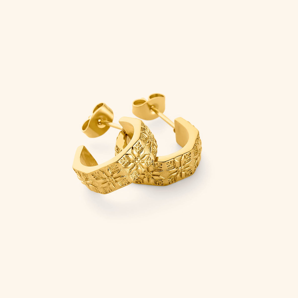 A pair of 18K gold plated thick hoop earrings traced with tatreez.