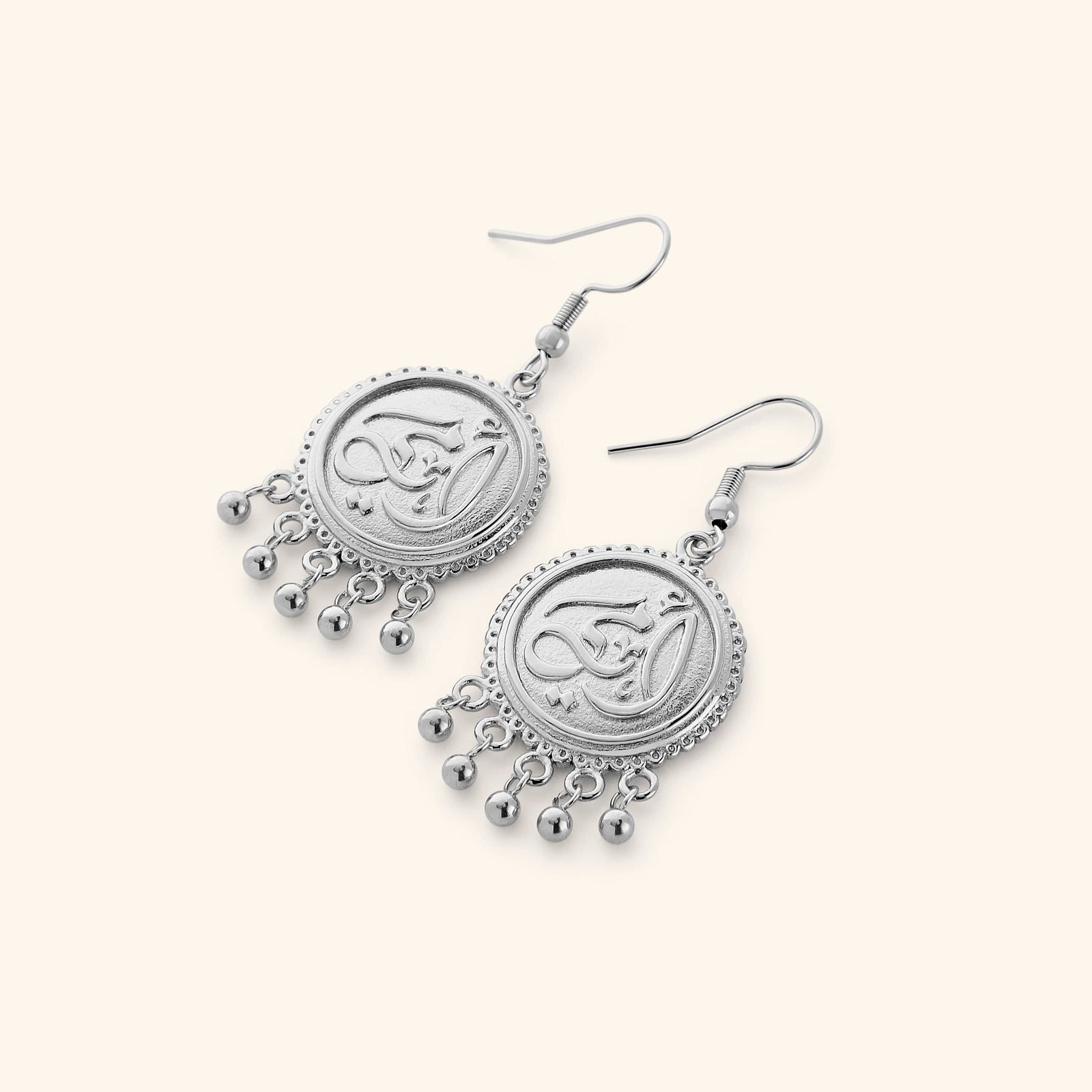 A pair of  silver dangling coin earrings that features "my mother" embossed in Arabic Calligraphy design finished with dancing orbs.