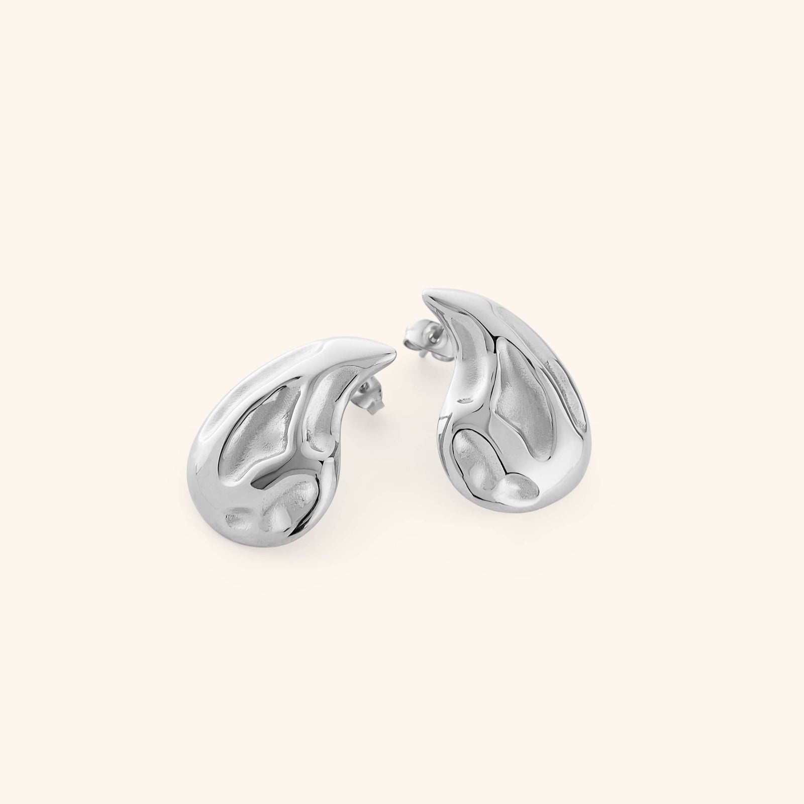 Pair of silver earrings shaped like a droplet, shot on a white background