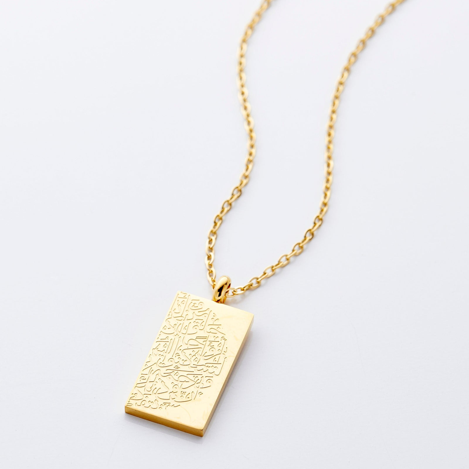 Flat lay of the gold "Tranquility in Them" Necklace against a light background.