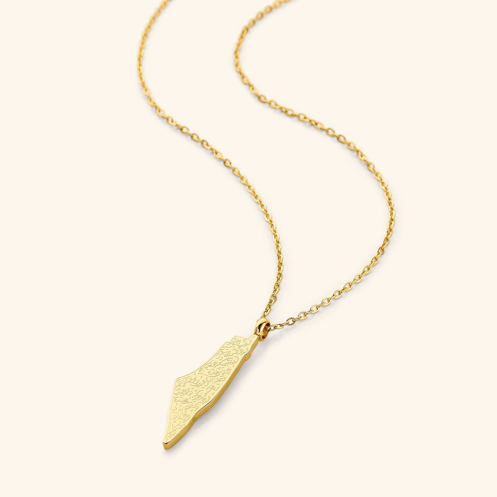 A gold-plated necklace featuring a pendant shaped like a country map, engraved with Arabic calligraphy of Ayatul Kursi, displayed on a white background.