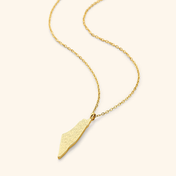 A gold-plated necklace featuring a pendant shaped like a country map, engraved with Arabic calligraphy of Ayatul Kursi, displayed on a white background.