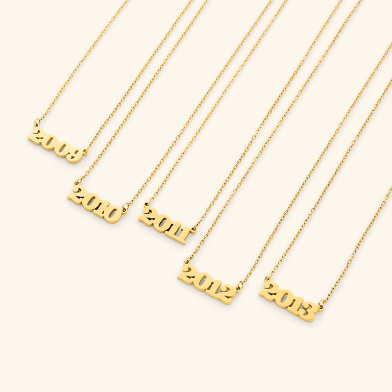 Gold necklace with english number pendants representing birth years on a white background