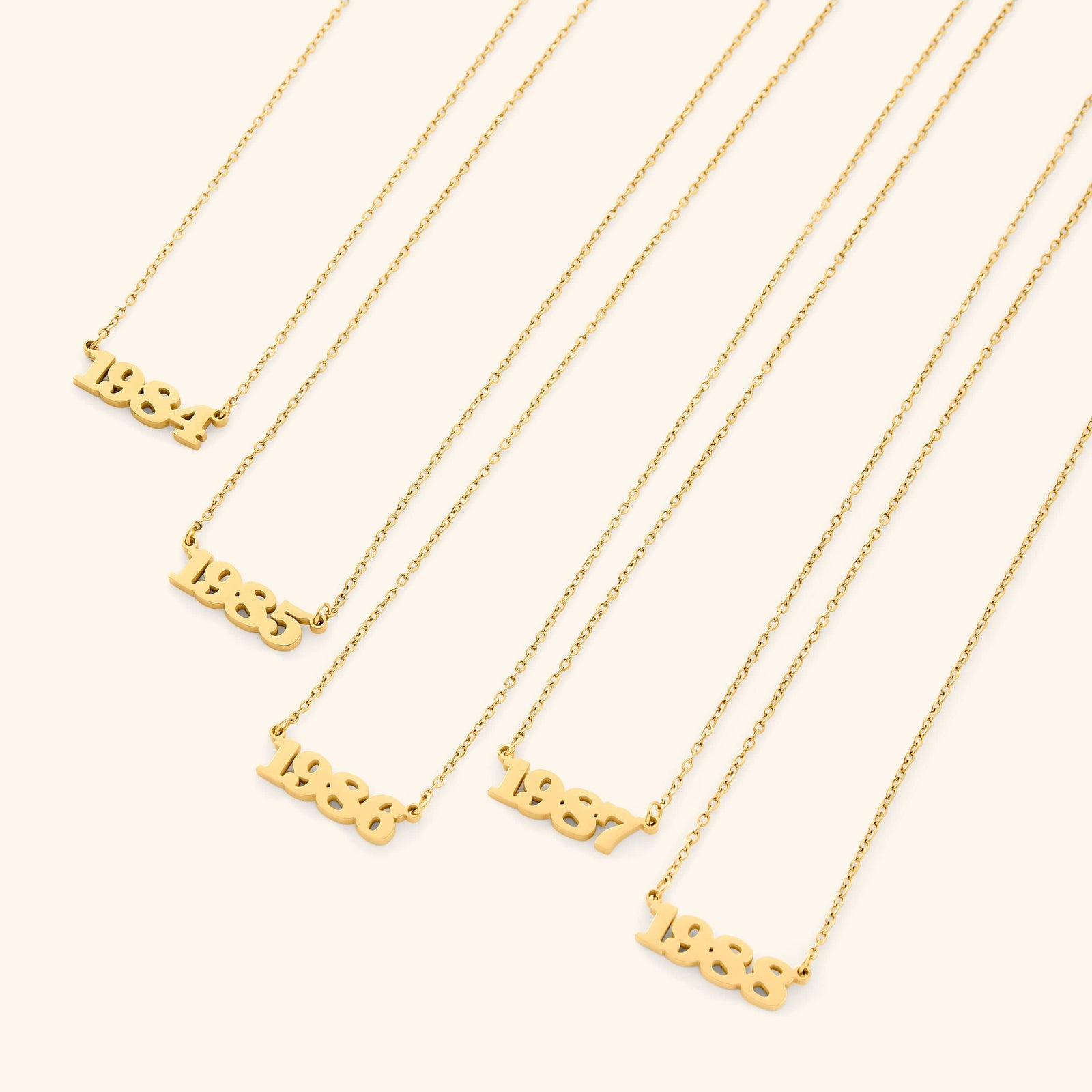 Gold necklace with english number pendants representing birth years on a white background
