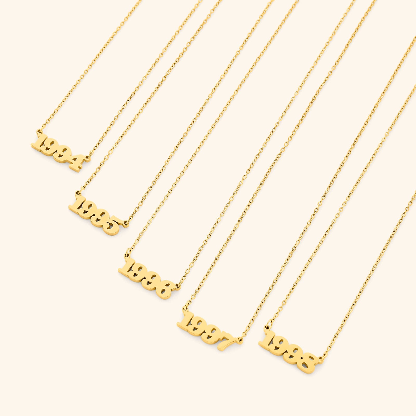 Gold necklace with english number pendants representing birth years on a white background